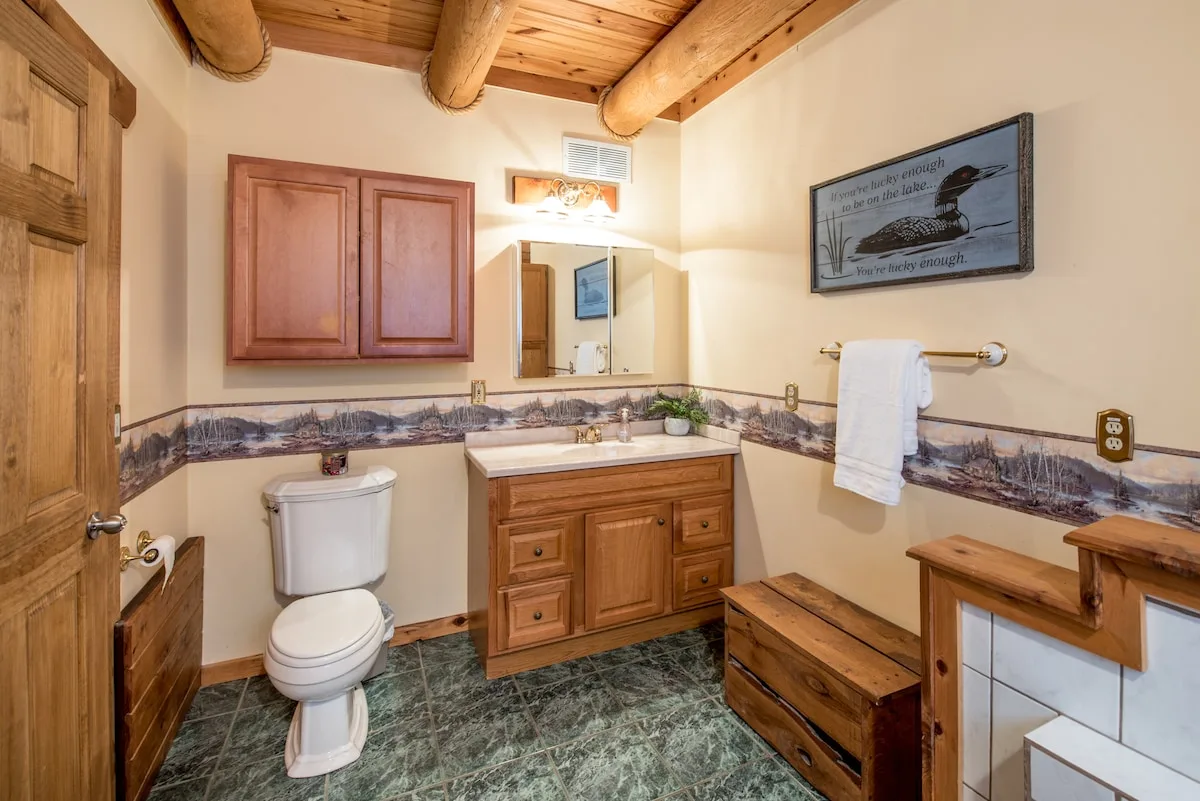 Main floor bathroom with wooden vanity, mirror, and clean modern fixtures