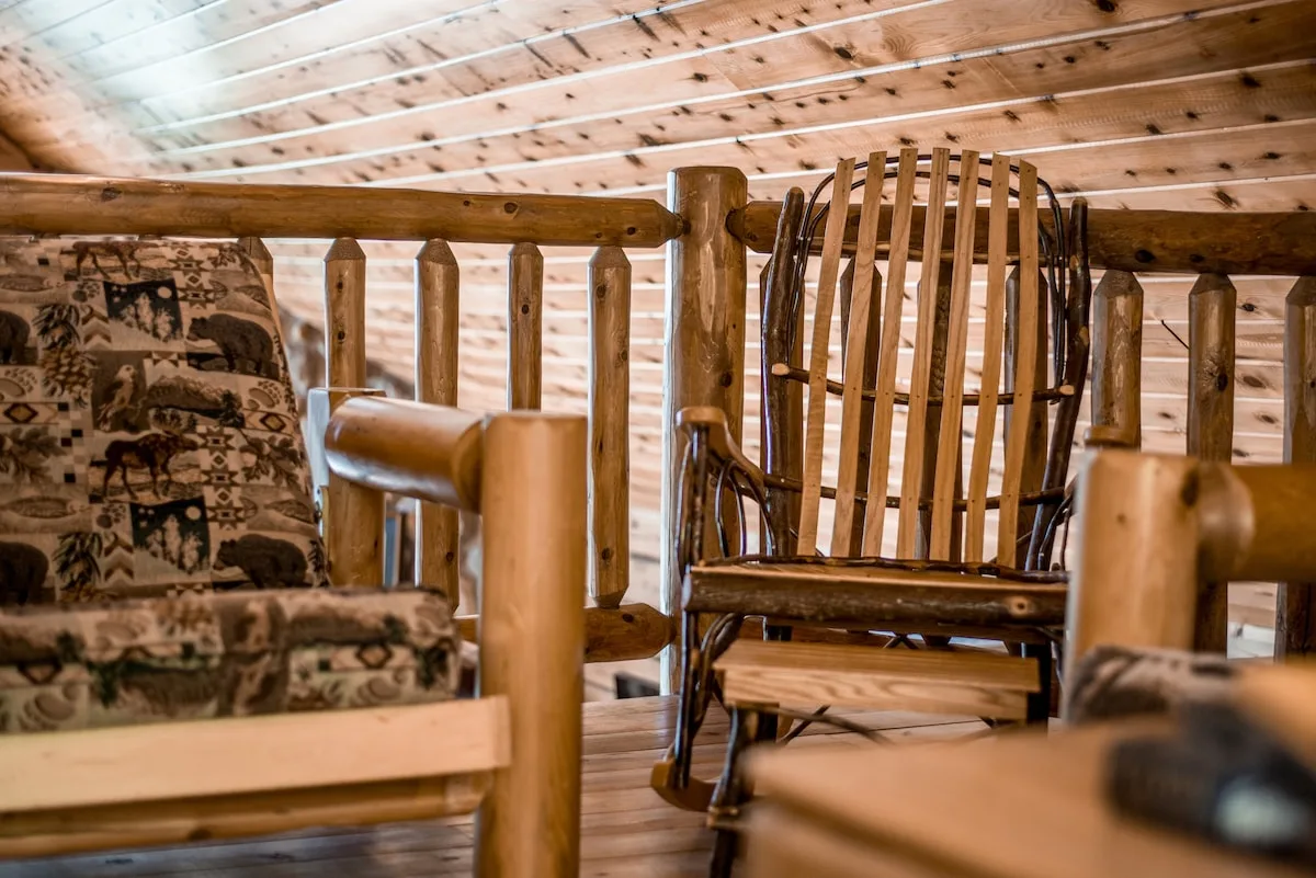 Loft reading chairs by the window with warm wood paneling and soft lighting