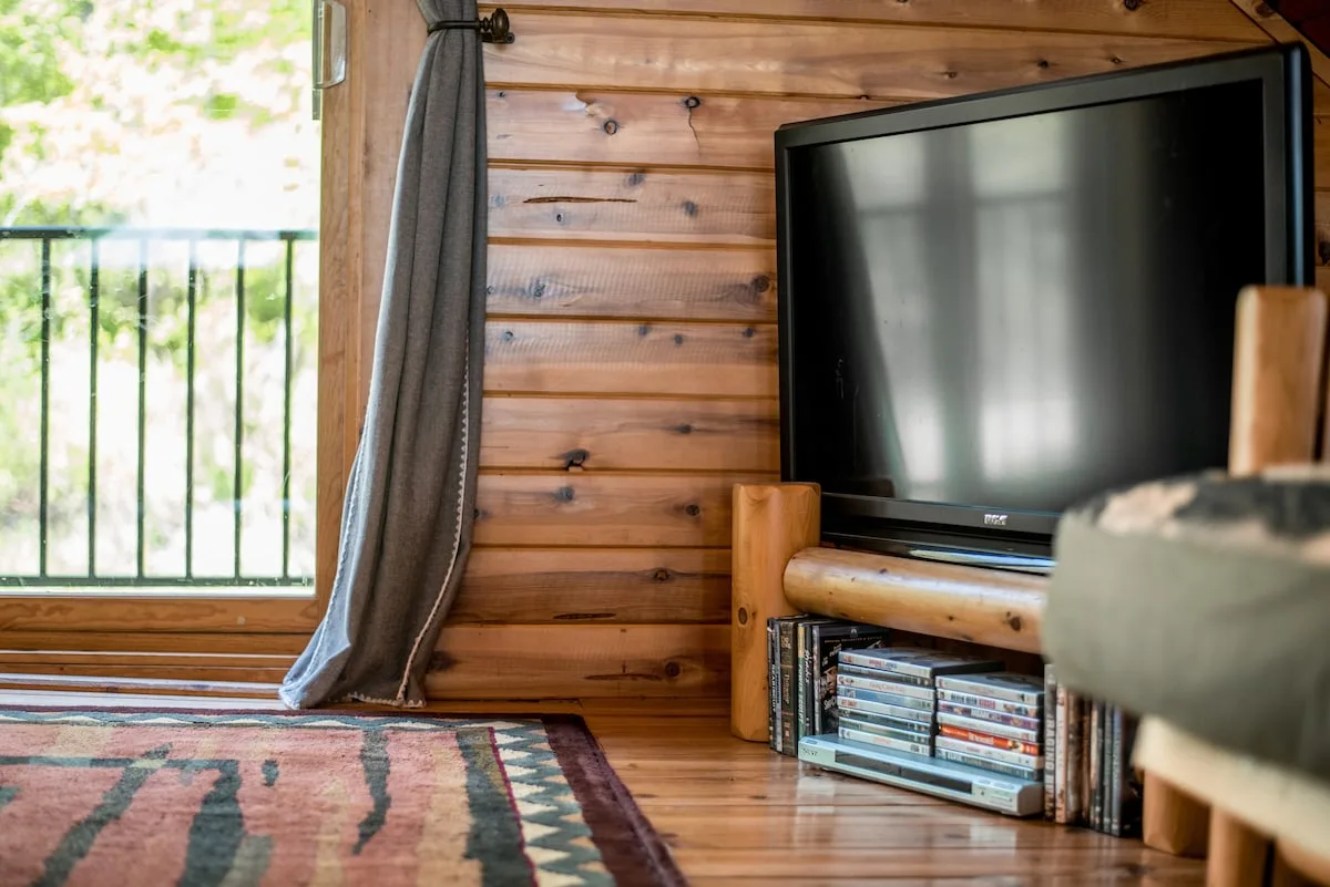 Loft TV area with flat screen and log furniture under vaulted cedar ceiling
