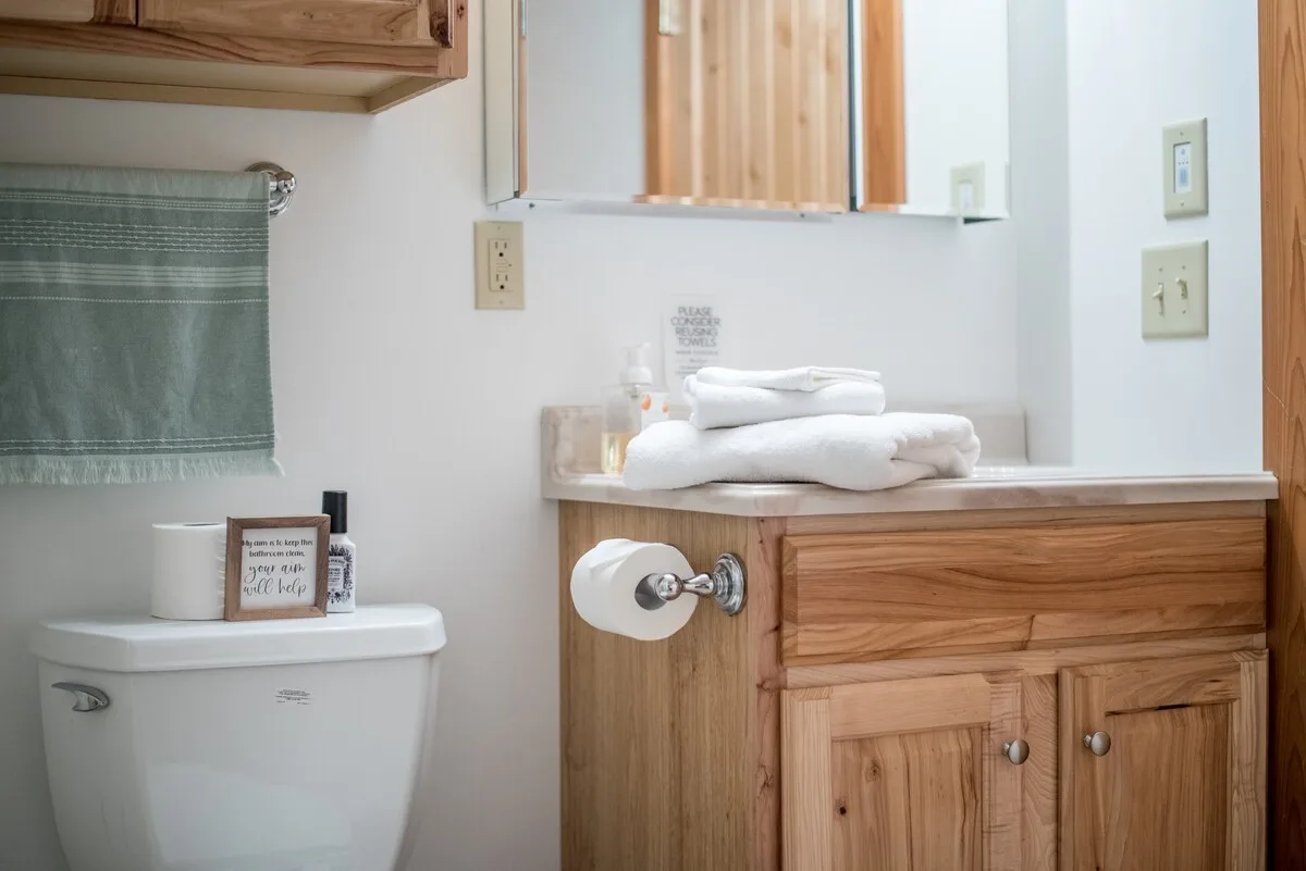 Clean bathroom vanity with folded white towels and toiletries